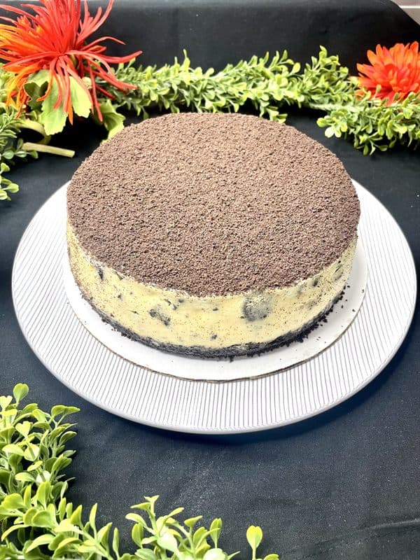 A whole cookies-and-cream cheesecake topped with cookie crumb.